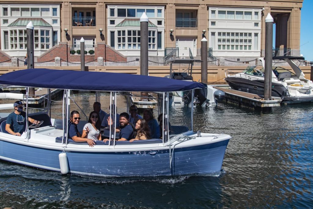 A group of passengers enjoying their private boat rental trip in Boston Harbor