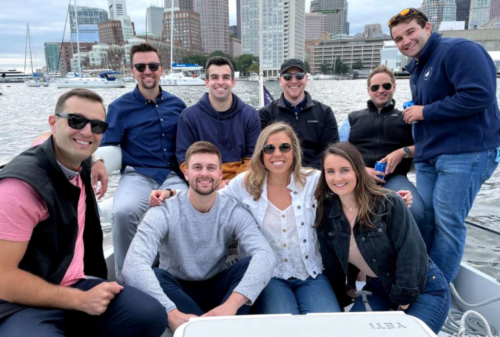 Group of men and women on a party boat in Boston smiling at the camera